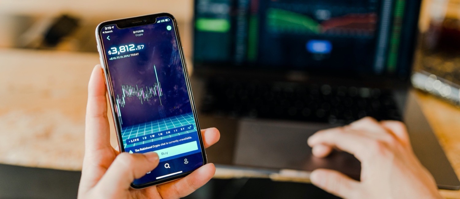 Man holding phone with graph on display