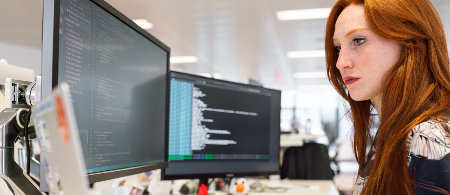 Woman sitting at desk on computer programming